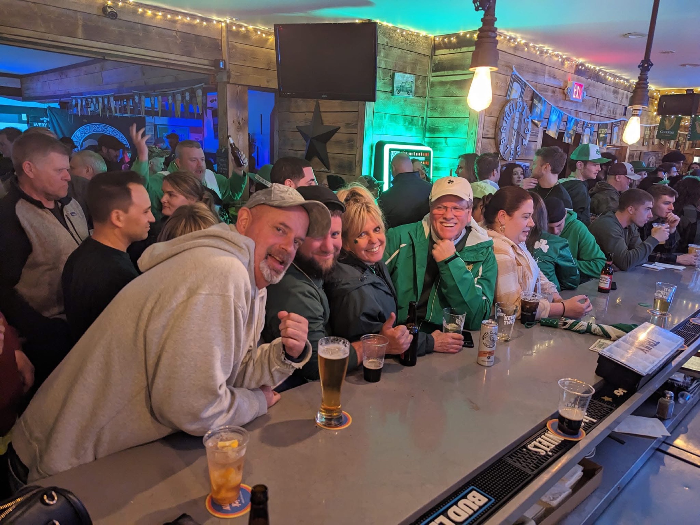 A packed crowd celebrating St. Patrick's Day at Stinsons Hub